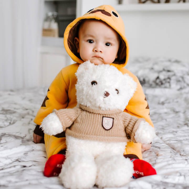 baby holding teddy bear