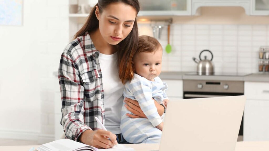 mother juggling baby and laptop