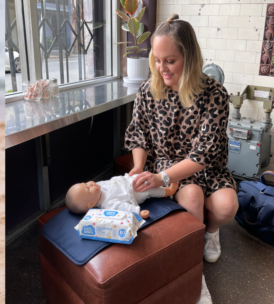 mother changing baby in cafe