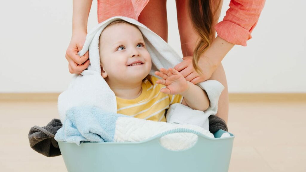 baby playing in laundry basket