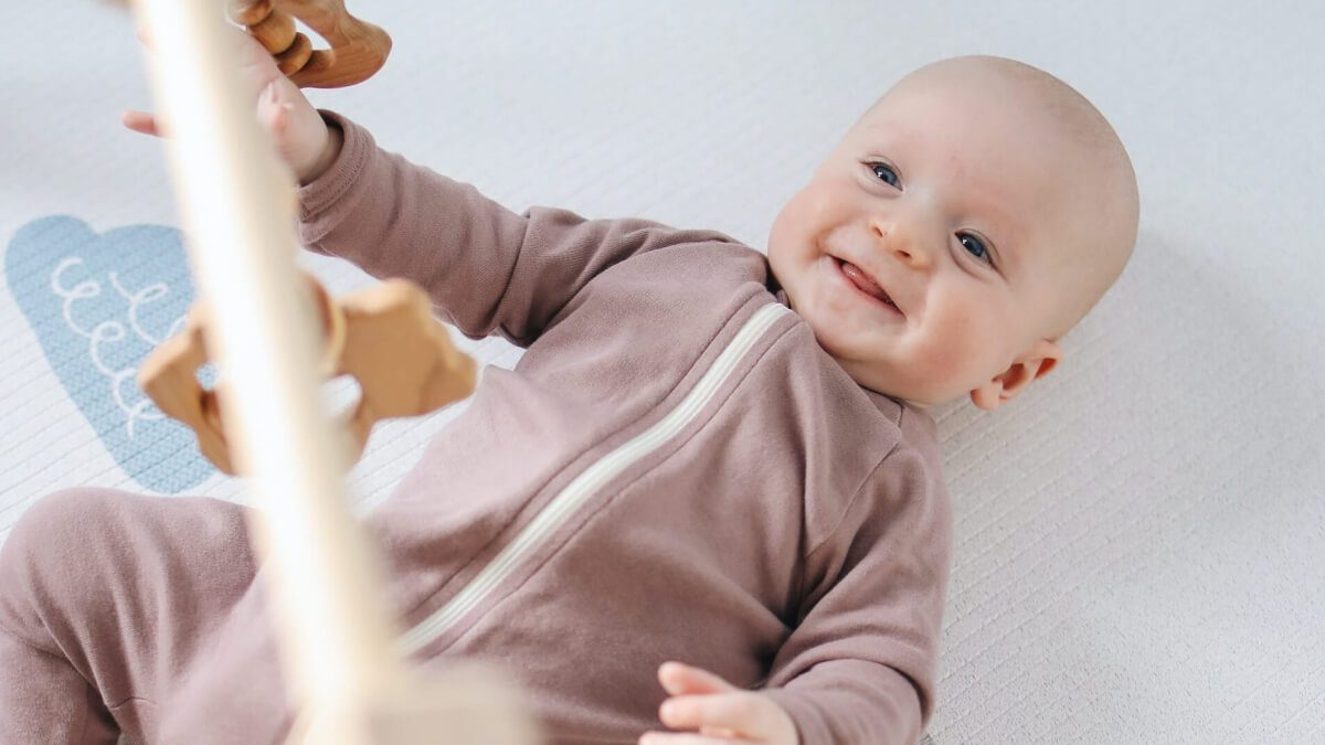 baby smiling under play gym