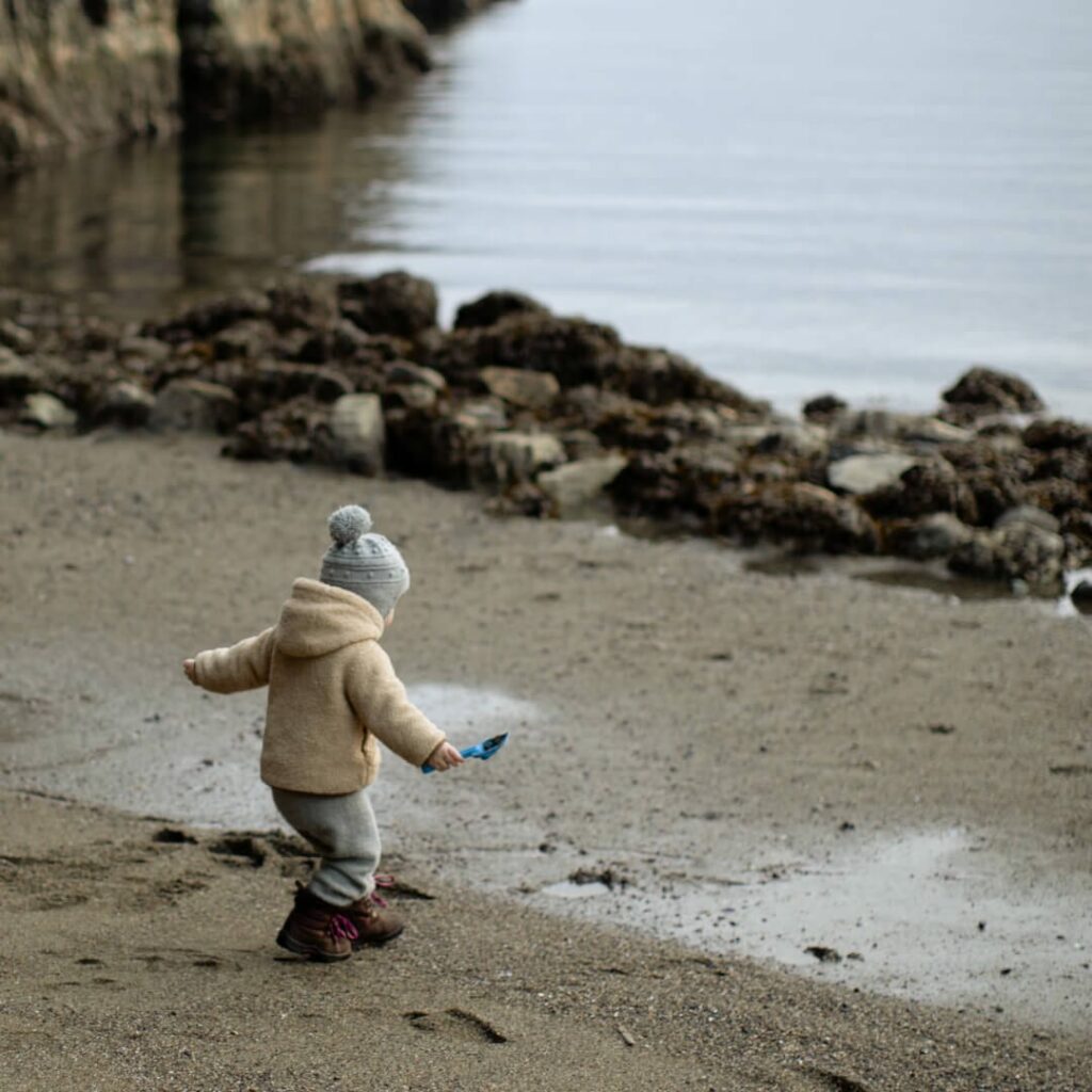 child playing at beach in winter