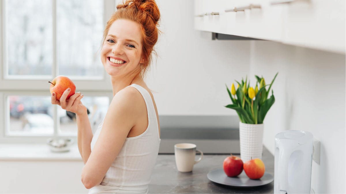 woman smiling eating apple